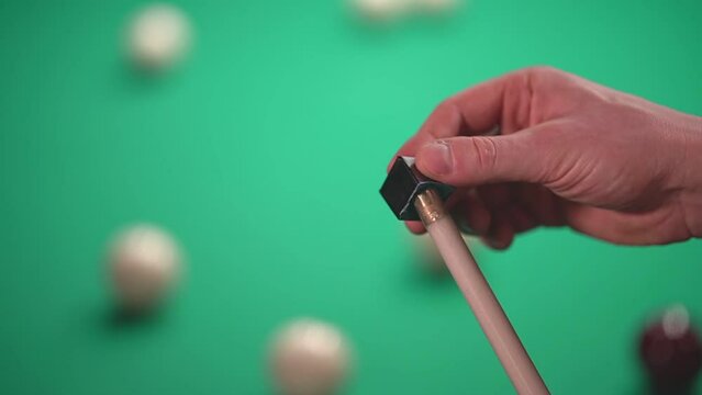 a man rubs a cue for playing Russian billiards with chalk, prepares to hit the billiard ball. close-up. High quality Full HD video recording. slow motion video