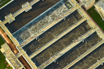 Fototapeta na wymiar Aerial view of modern water cleaning facility at urban wastewater treatment plant. Purification process of removing undesirable chemicals, suspended solids and gases from contaminated liquid