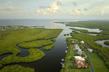 Aerial view of rural private houses in remote suburbs located near Florida wildlife wetlands with...