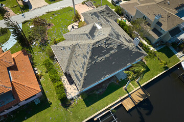 Hurricane Ian destroyed house roof in Florida residential area. Natural disaster and its consequences