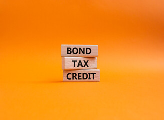 Bond Tax Credit symbol. Concept word Bond Tax Credit on wooden blocks. Beautiful orange background. Business and Bond Tax Credit concept. Copy space