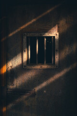 vintage metal door with bars in window secure a dark prison cell