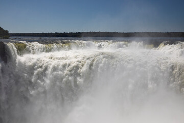 Nature's power. View of the Iguazu waterfalls and river, seen from Garganta del Diablo, in Misiones, Argentina. The amazing falls and falling white water beautiful texture, mist and splash.