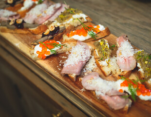 Catering table, beautifully decorated banquet table with variety of different food snacks, sandwiches, croissants and appetizers on a party event or celebration, delicatessen setting, coffee break