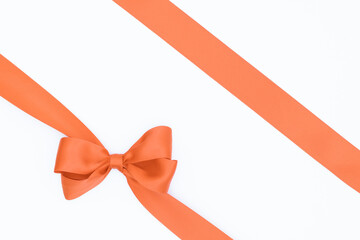 Nœud de ruban de satin pour paquet cadeau de couleur orange, isolé sur du fond blanc....