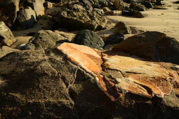 Geological formation of colorful stones with different layers, sand, fossil rocks on Magoito beach, Atlantic ocean coast near Lisbon