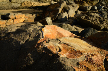 Geological formation of colorful stones with different layers, sand, fossil rocks on Magoito beach, Atlantic ocean coast near Lisbon