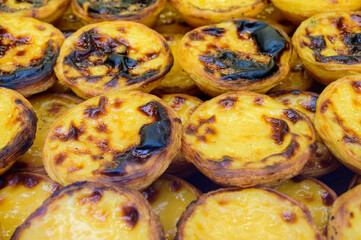 Portugal's traditional sweet dessert Pastel de nata egg custard tart pastry served with view on display in bakery, Lisbon area, Portugal