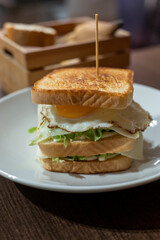 Vegetarian club sandwich with white bread, egg, green lettuce and cheese