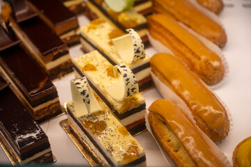 Assortment of french fresh baked sweet pastry with fresh fruits and berries in confectionery shop
