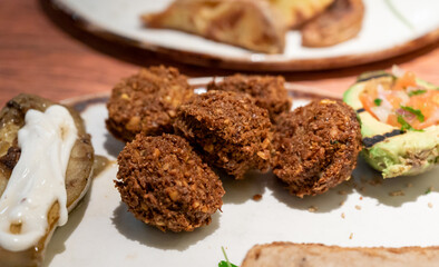 Healthy vegetarian food, vegan falafel balls served with grilles baked eggplant and grilled avocado