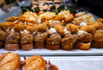 Typical snack of Basque Country, pinchos or pinxtos, small piece of bread with different fish and sea food toppings, served in bar in San-Sebastian or Bilbao, Spain