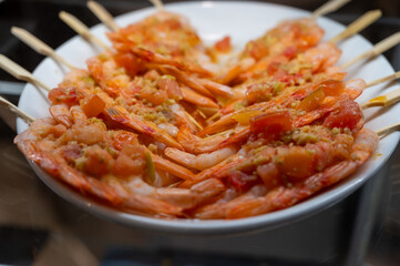 Typical snack of Basque Country, pinchos or pinxtos skewers with small pieces different fish and sea food, served in bar in San-Sebastian or Bilbao, Spain