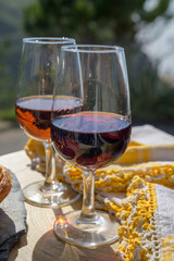 Portugal's food and drink, glass of porto wine, muscatel de setubal and sweet dessert Pastel de nata egg custard tart pastry served with view on blue Atlantic ocean in Lisbon area, Portugal