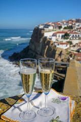 Glasses of champagne sparkling wine and view on white houses of picturesque village Azenhas do mar, Lisbon area, Portugal