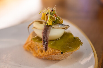 Board with typical snack of Basque Country, pinchos or pinxtos skewers with small pieces of bread, sea food, eggs, cheese served in bar in San-Sebastian or Bilbao, Spain