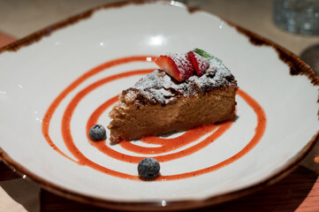 Delicious fresh baked colorful decorated vegan almond cake with fruits served in vegan restaurant in Bilbao, Basque Country, Spain