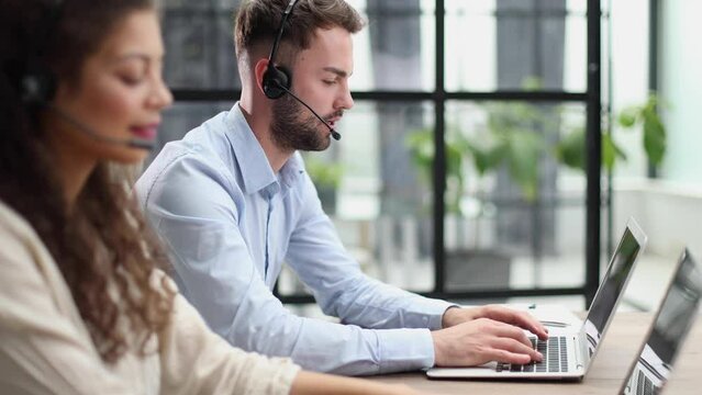 Guy from technical customer service support answering voice calls from clients in office