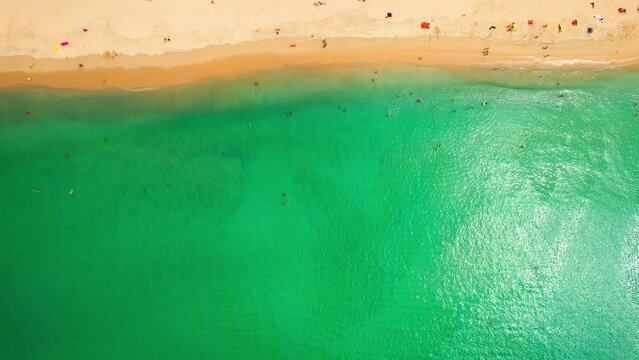 Travelers sunbathing on beach against sea in summer. Kata Noi Beach, Phuket is a paradise and destination for tourists from all over the world. aerial view. nature background. travel concept. 4K.
