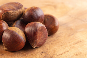 A Pile of Raw and Whole Chestnuts on a Wooden Table