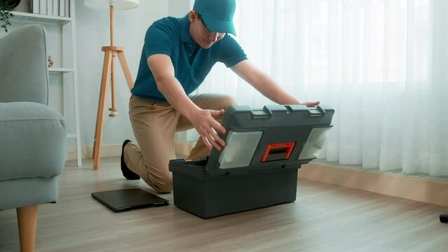 An Asian young Technician service man wearing blue uniform checking electrical appliances in home