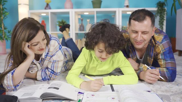 Adult parents help their primary school student sons with their lessons.
Parents helping with homework by lying on the carpet at home. Child education concept.
