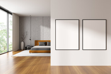 Bright bedroom interior with two empty white posters