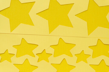 yellow paper stencil with stars on yellow corrugated paper texture