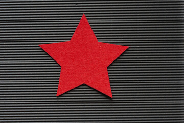 grungy red felt star isolated on black corrugated texture