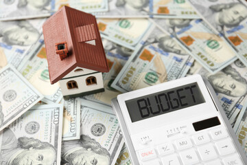 Budget plan. Calculator and house model on dollar banknotes