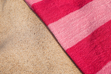 Soft pink beach towel on sand, above view. Space for text