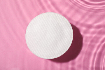 Cotton pad and micellar water on pink background, top view © New Africa