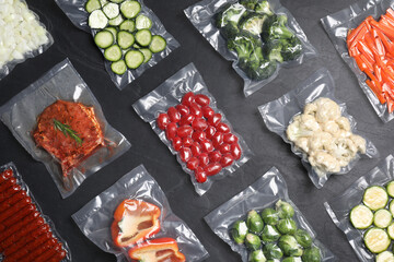 Flat lay composition of different food in vacuum packings on dark grey table - obrazy, fototapety, plakaty