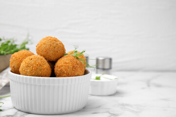 Bowl of delicious fried tofu balls with pea sprouts on white marble table, space for text