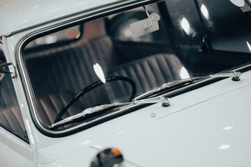 front view of a creamy white vintage car There is a reflected light that resembles a heart shape