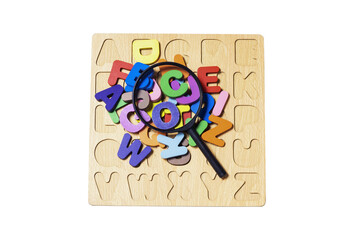 English alphabet made of square wooden tiles with the English alphabet scattered on white background. The concept of thinking development, grammar. Magnifier placed on English letters, clipping  paths