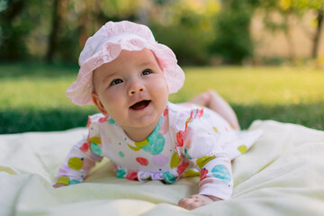 Baby girl is smiling in garden on the lawn