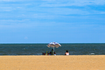 Sao Joao da Barra, RJ, Brazil, 2022 - A bather watches the sea under an umbrella on the Grussai Beach