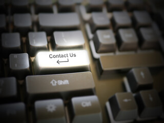 A glowing bright 'contact us' button, key, message on the keyboard. Customer service concept. Internet or online contact for services and businesses.
