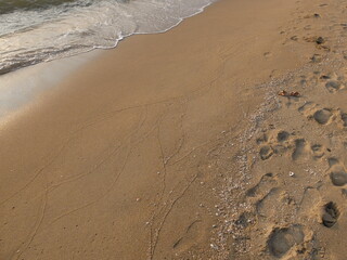 Footprints texture on the sand and sea wave, Jomtien beach, Pattaya, Thailand