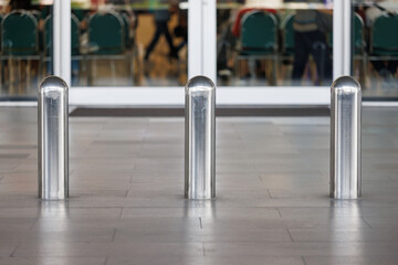 stainless steel bollards on footpath walkway near the entrance of office and hotel building.