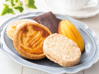 皿に盛った色々な焼き菓子とカップ