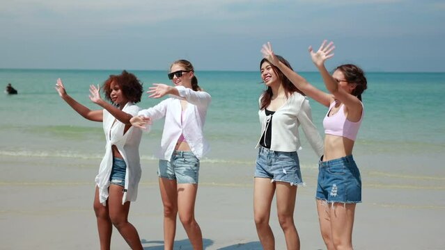 Slow motion. Group of teenager girls walking on beach. Four teenager girl female enjoying and walking on tropical beach. Vacation trip summer holiday.