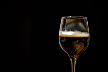Dark beer in a glass on a black background.