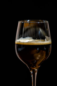 Dark beer in a glass on a black background.