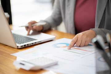 Businesswoman Accountant analyzing investment charts Invoice and pressing calculator buttons over documents. Accounting Bookkeeper Clerk&nbsp;Bank Advisor And Auditor Concept