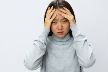Asian woman holding her hand to her head for severe headache, migraine white background