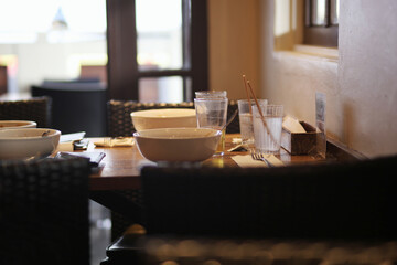 Restaurant tables with dirty dishes left in natural light
