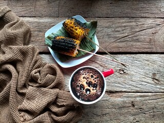 cup of coffee with cinnamon on wood background