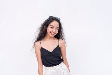 A young and radiant Filipino woman with long curly hair in her early 20s. Wearing a black spaghetti strap blouse. Isolated on a white background.